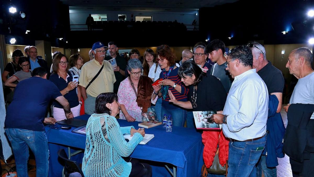La escritora firmando libros al público asistente