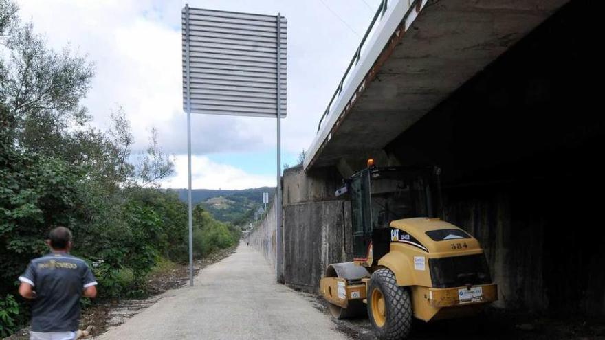 Un usuario pasa junto a una de las máquinas utilizadas en las obras de mejora que se están llevando a cabo en la pista.