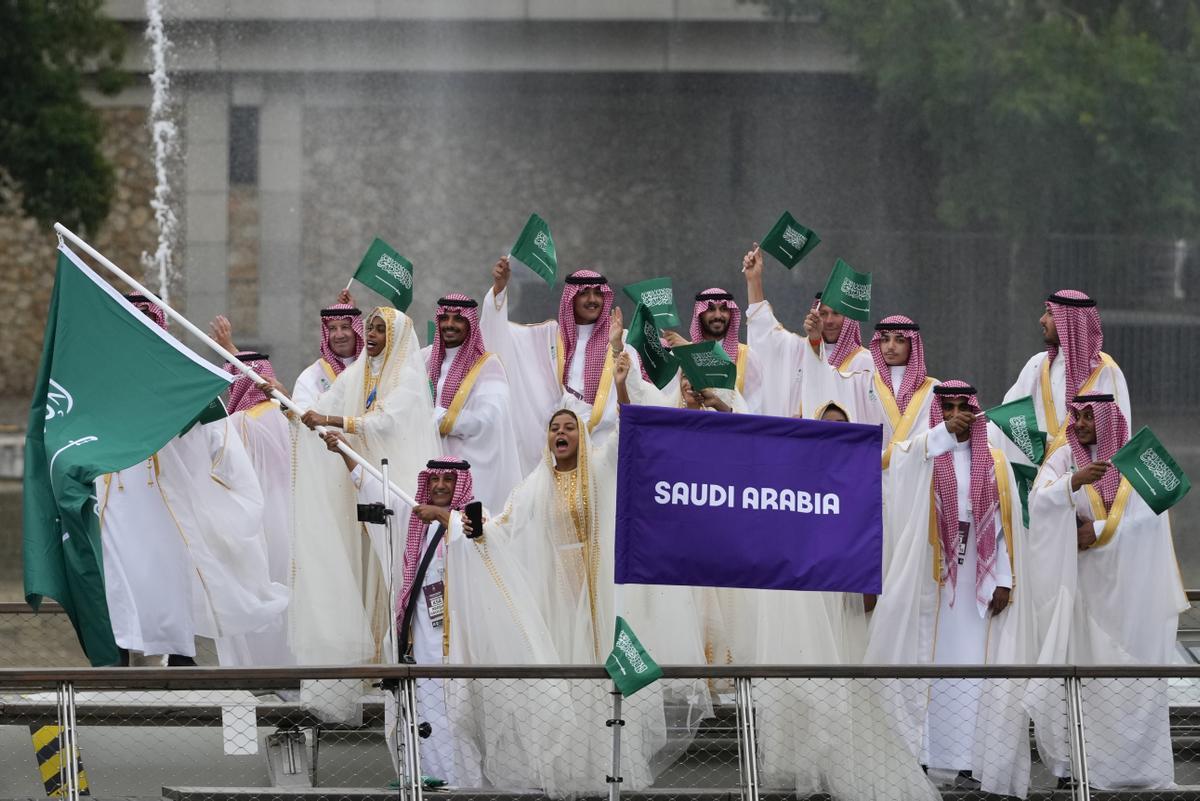 El equipo de Arabia Saudí ondea banderas en un barco en París, Francia, durante la ceremonia de inauguración de los Juegos Olímpicos
