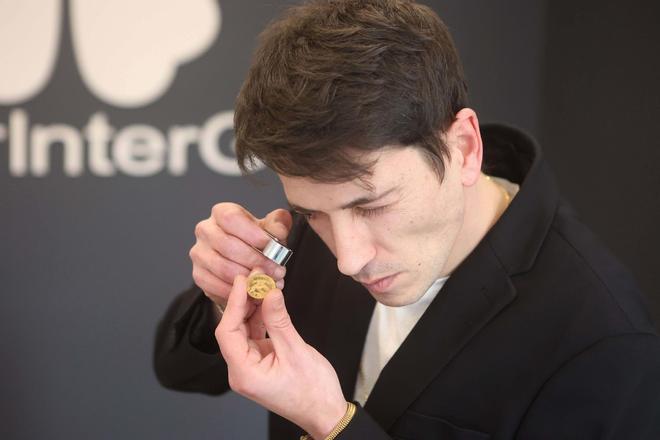 Zanit Pampín analiza una moneda de oro