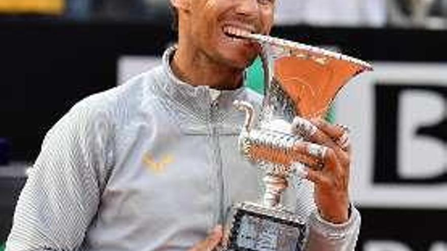 Nadal muerde el trofeo. // E. Ferrari