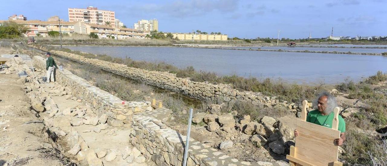 Pedro García, director de ANSE, levanta una de las compuertas que ayudará a redirigir el agua hacia las salinas.