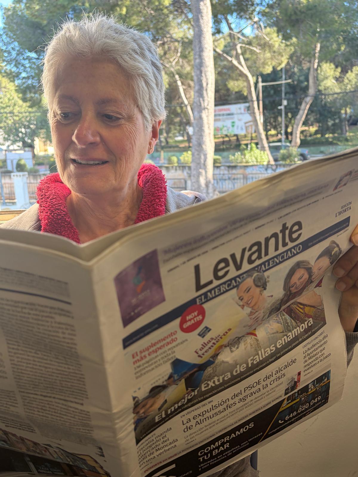 Mecedes ojea un ejemplar del periódico Levante-EMV de la edición de l'Horta.