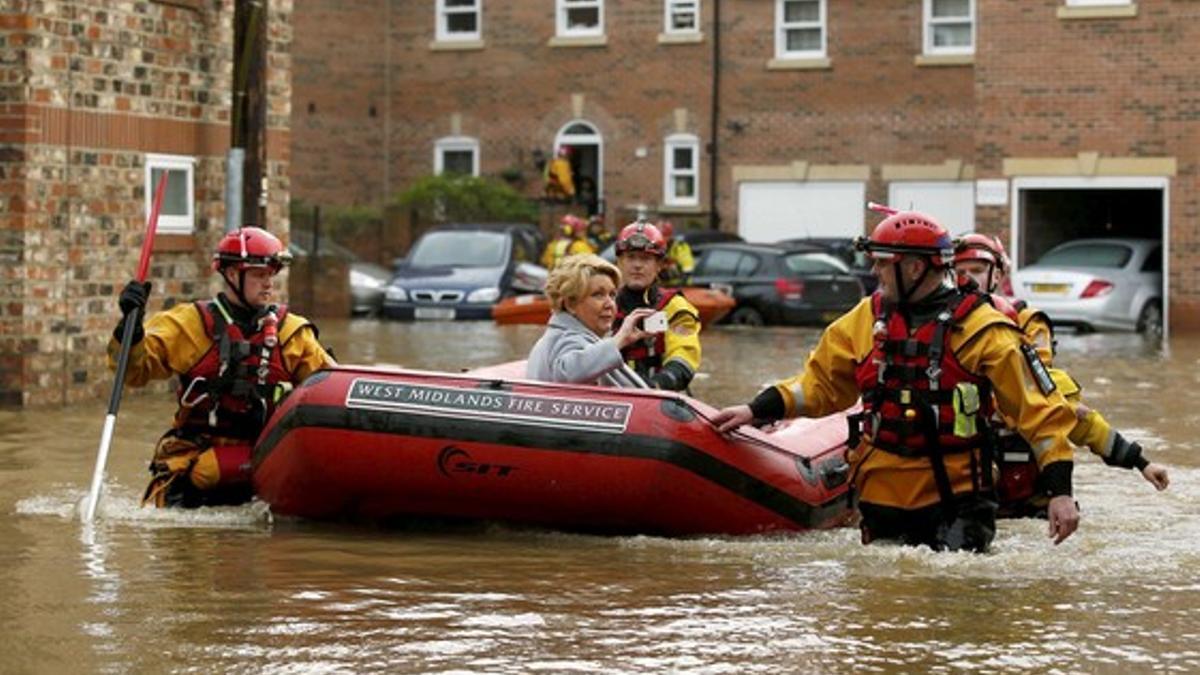 Miembros de los servicios de emergencia rescatan a una mujer de una casa inundada en York, este lunes.