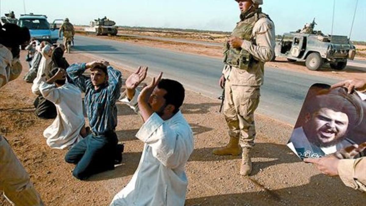 Soldados de EEUU interrogan a iraquís detenidos en la cuneta de una carretera, en mayo del 2004.