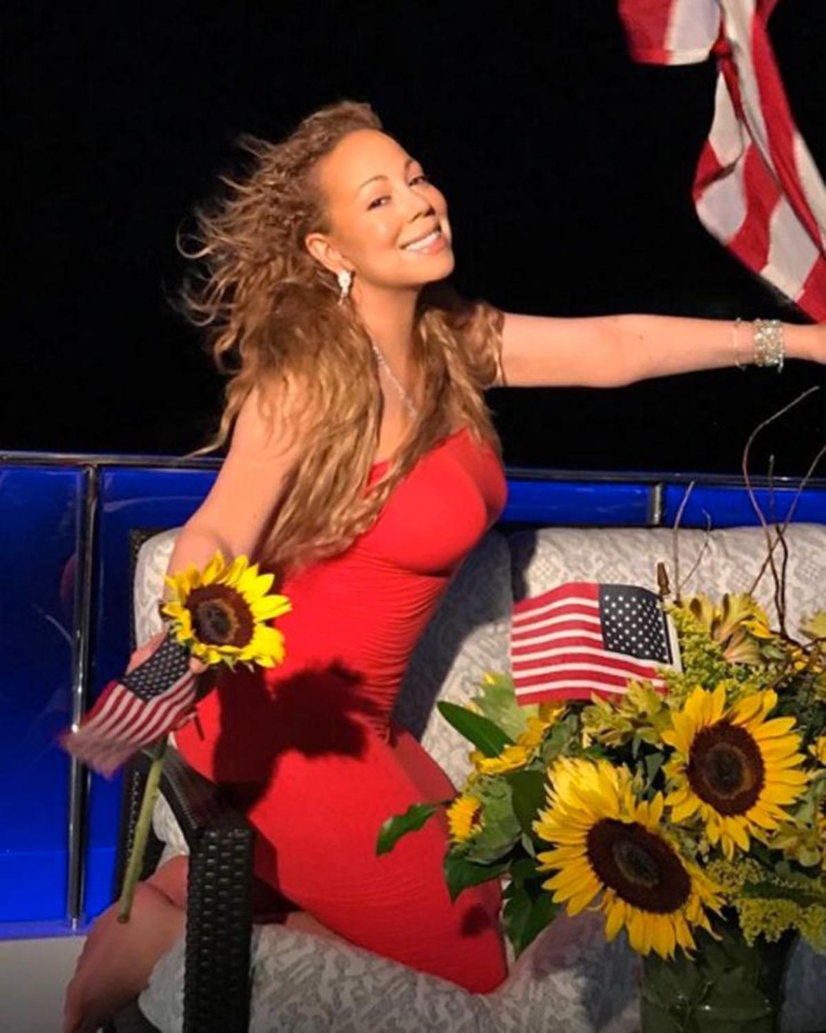 Mariah Carey de rojo y con la bandera de Estados Unidos