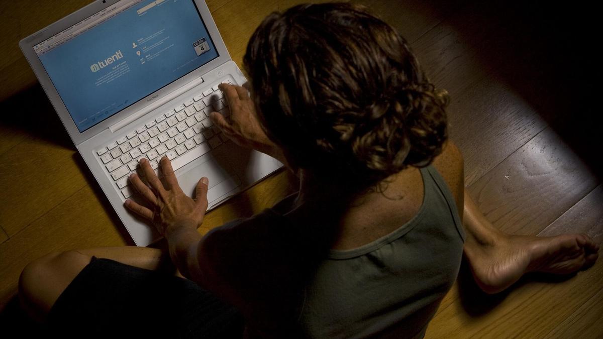 Una mujer escribe en el teclado de su ordenador.
