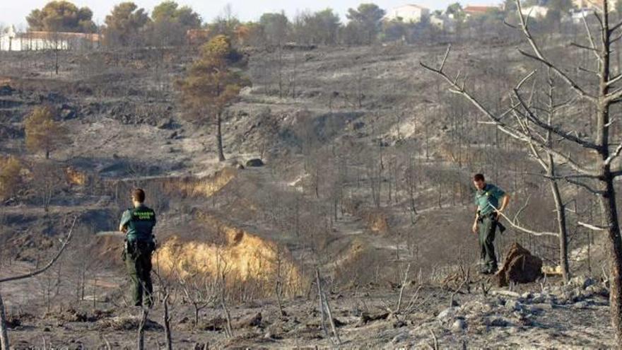 Dos agentes de la Guardia Civil inspeccionan el pasado martes una de las zonas arrasadas por el fuego en Xàbia.