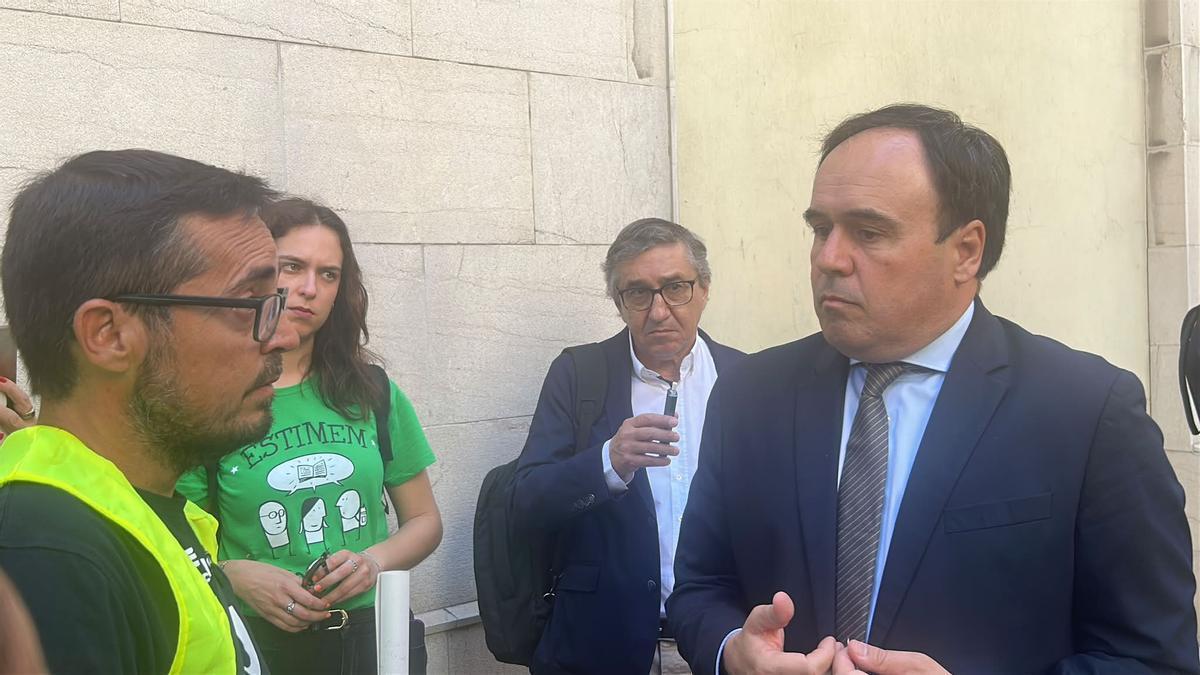 Pérez Llorca conversa con miembros del colectivo de docentes a su salida de las Corts.