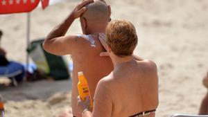 Dos personas poniéndose crema solar.