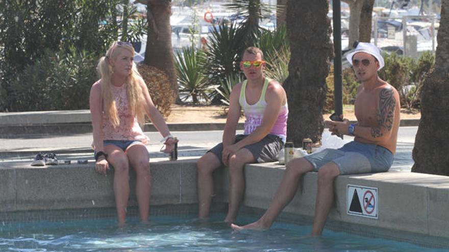 Tres turistas se refrescan en las fuentes de Sant Antoni.