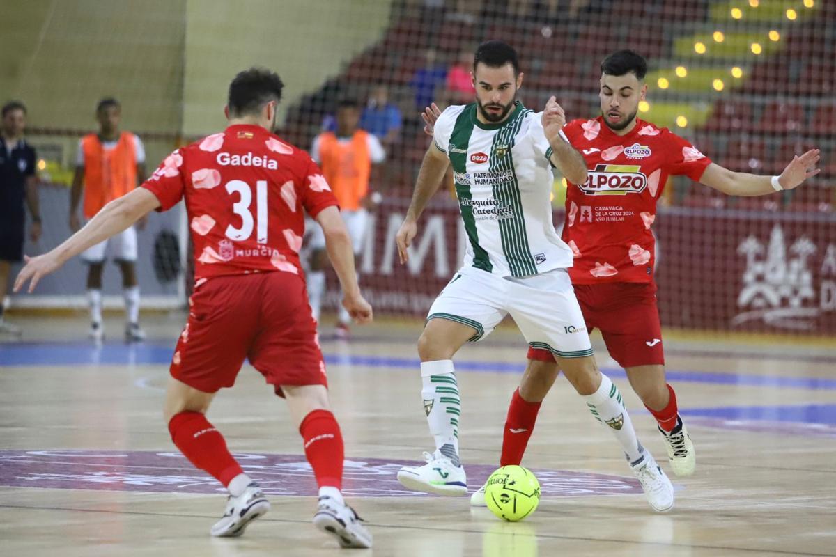 Juanan conduce el balón ante dos rivales en el Córdoba Futsal-El Pozo Murcia.