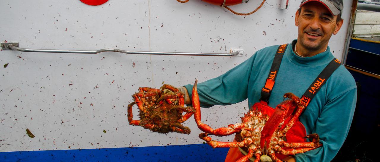 Un pescador mostrando un centollo y una centolla, en O Grove.