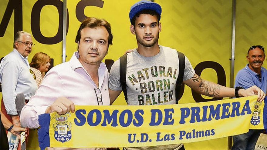 El delantero brasileño Willian José posa con una bufanda de la UD, junto al director General Deportivo, Toni Cruz, ayer, en el Aeropuerto de Gran Canaria.