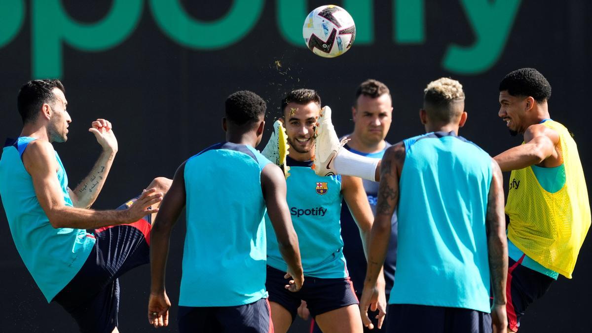 Busquets y Araujo pugnan por un balón con Eric Garcia, en el centro, atento.