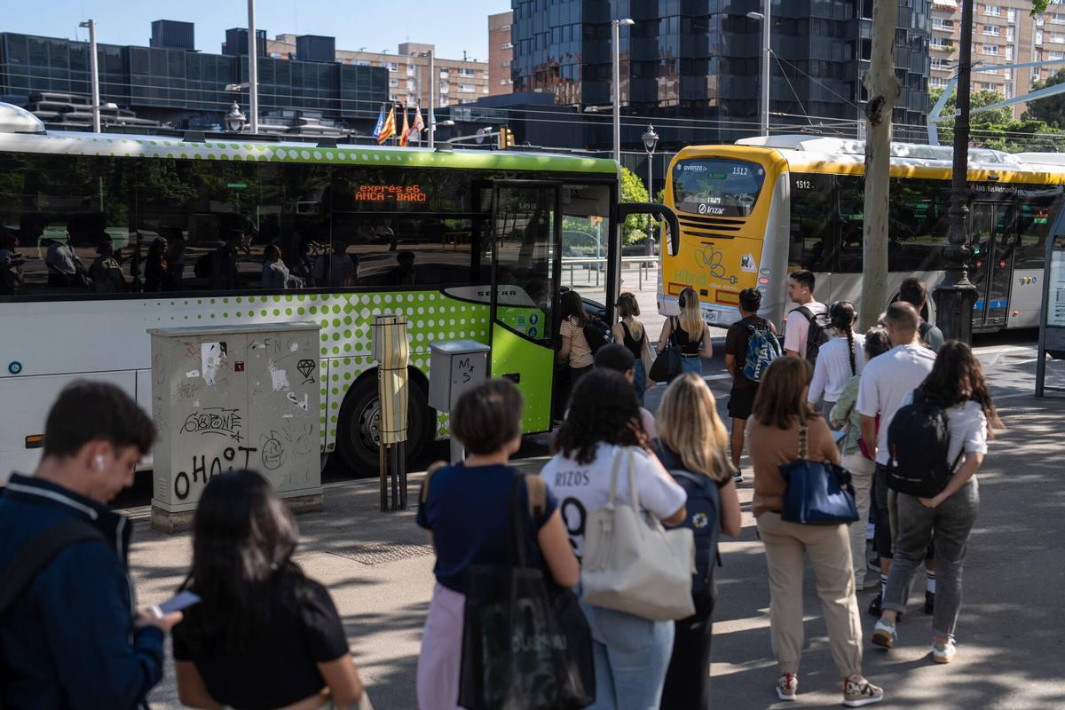 Usuarios hacen cola para subir a los autobuses en las paradas de Diagonal con Maria Cristina.