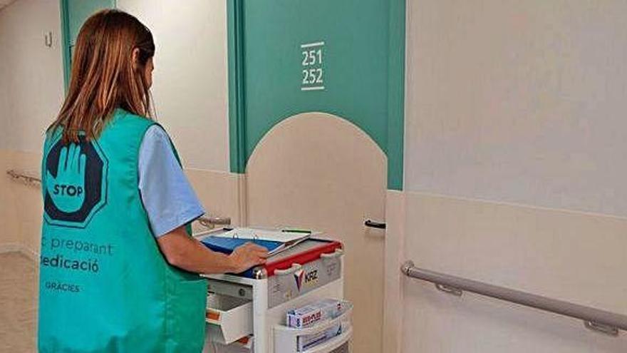 Una infermera amb l&#039;armilla mentre prepara medicació en un dels passadissos de l&#039;Hospital de Sant Andreu