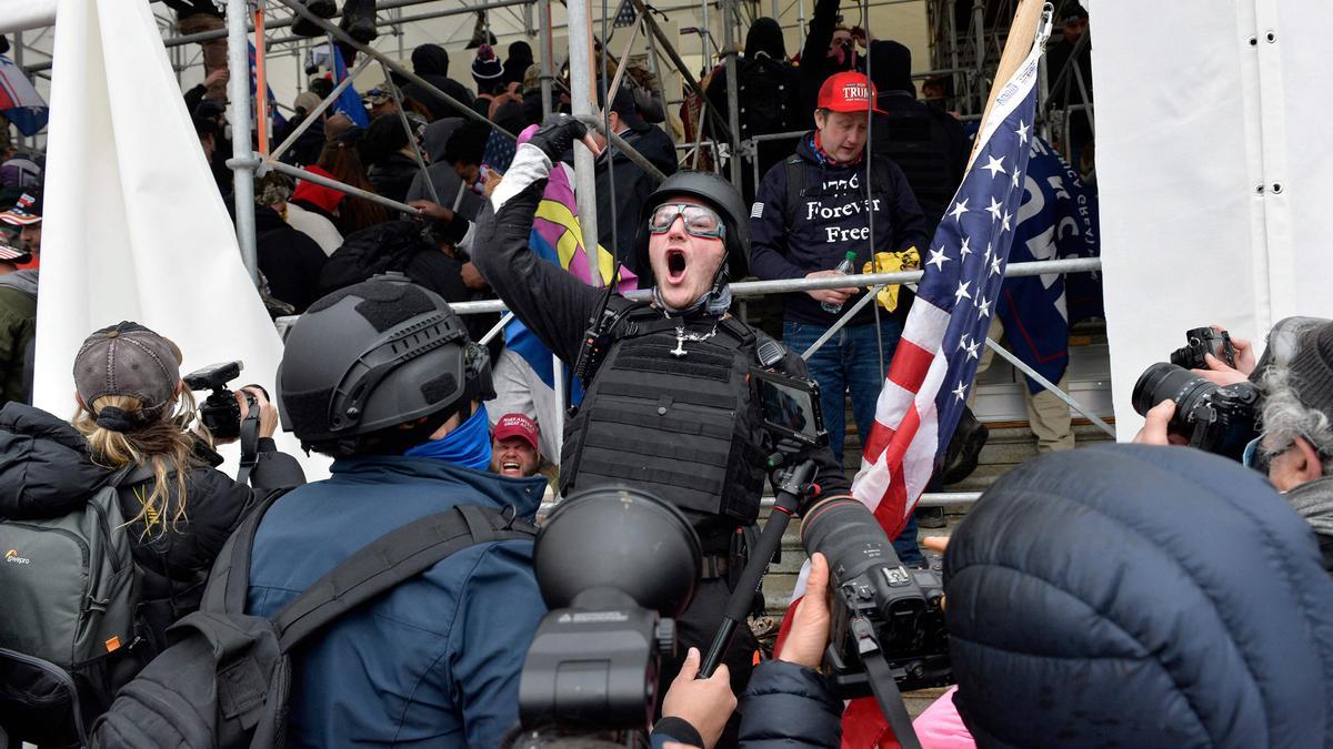 Un hombre pide a la gente que asalte el edificio mientras los partidarios de Trump chocan con la policía y las fuerzas de seguridad mientras intentan asaltar el Capitolio de EE. UU.