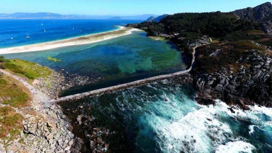 Imagen aérea del Lago dos Nenos, con el dique en primer término y la playa de Rodas al fondo.  // Ricardo Grobas