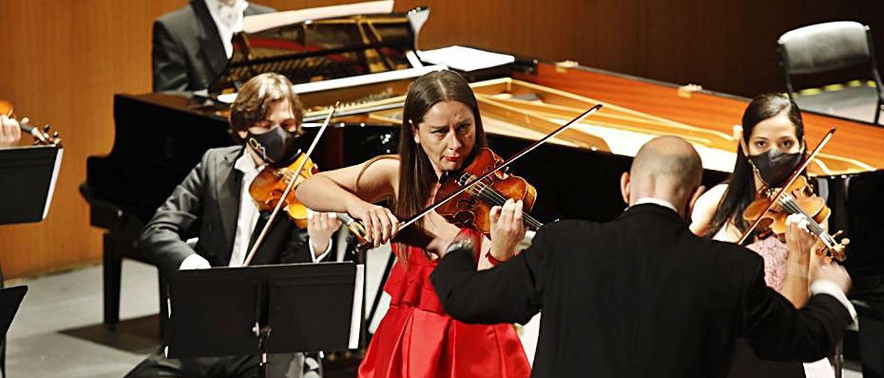 La violinista Elena Mikhailova junto al director Mariano Rivas, de espaldas, durante el concierto de Año Nuevo en el Jovellanos. | Ángel González