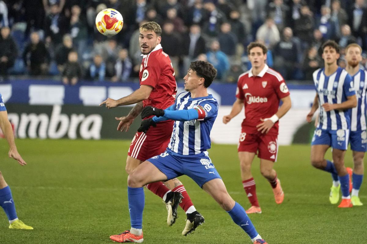 VITORIA, 17/12/2025.- El centrocampista del Alavés, Antonio Blanco (d), disputa el balón ante el delantero del Sevilla, Isaac Romero, durante el encuentro correspondiente a los dieciseisavos de final de la Copa del Rey que disputan hoy miércoles Alavés y Sevilla en el estadio de Mendizorroza, en Vitora. EFE / L. Rico