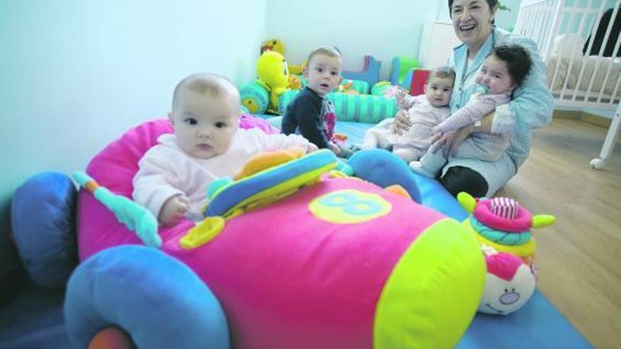 Los cuatro alumnos del aula de bebés menores de un año, con su cuidadora.