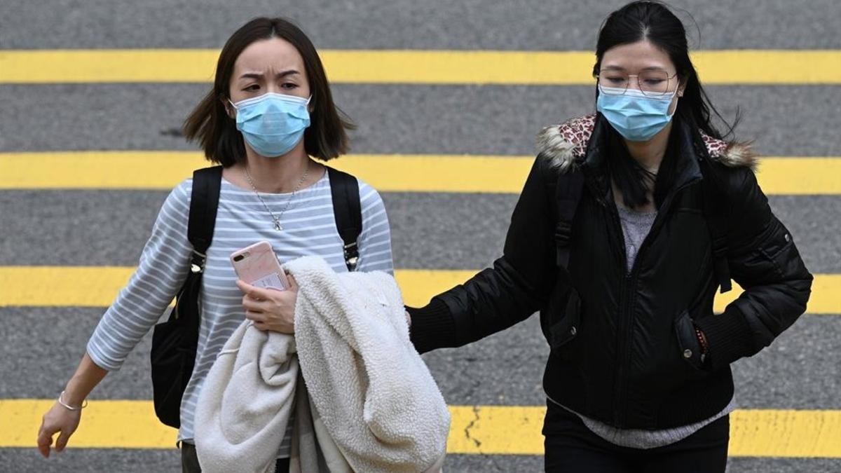 Dos mujeres con máscara, como prevención frente al brote de coronavirus, en Hong Kong