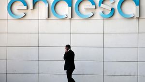 A man walks under the logo of Spanish power company Endesa at their headquarters in Madrid, Spain, April 26, 2016. REUTERS/Andrea Comas