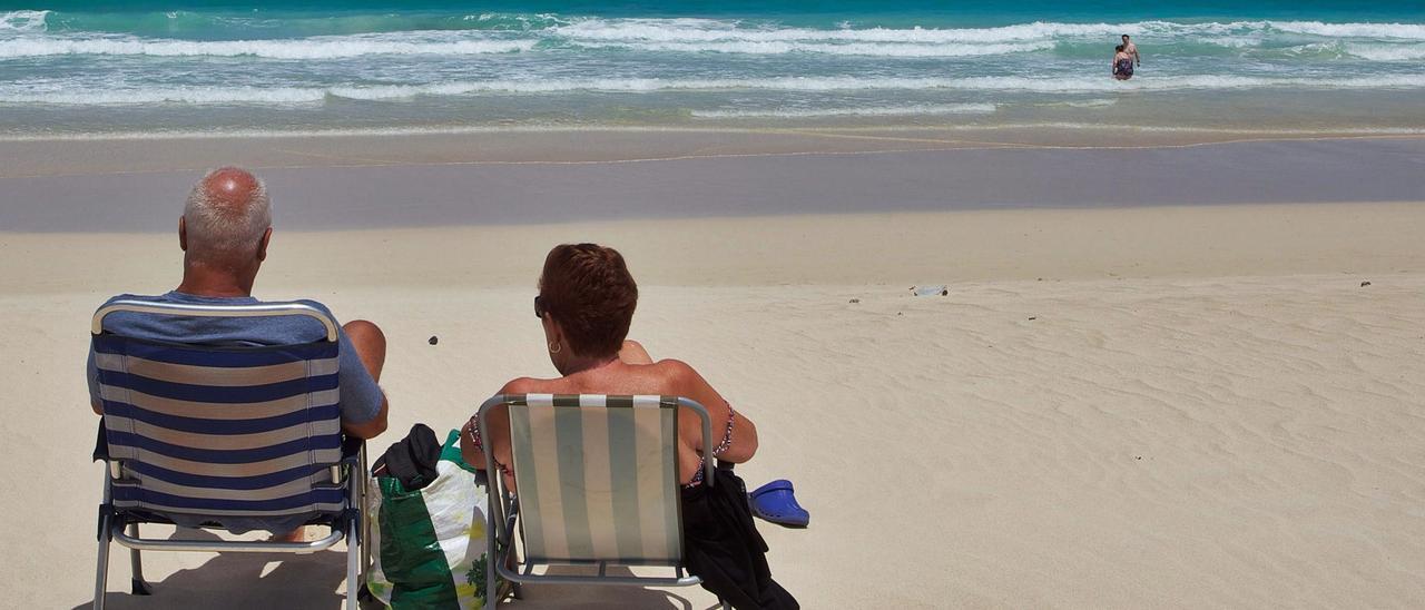 Turistas descansan en una playa de la localidad majorera de Corralejo.  | | CARLOS DE SAÁ / EFE