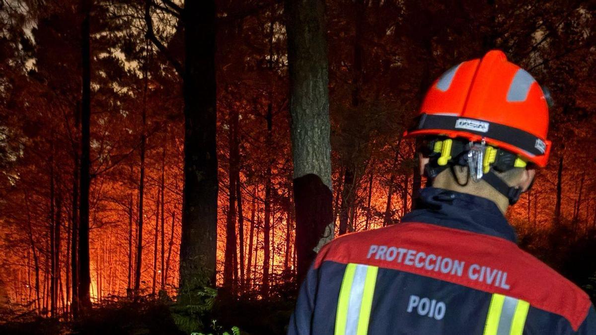 Un voluntario de Protección Civil ante el incendio