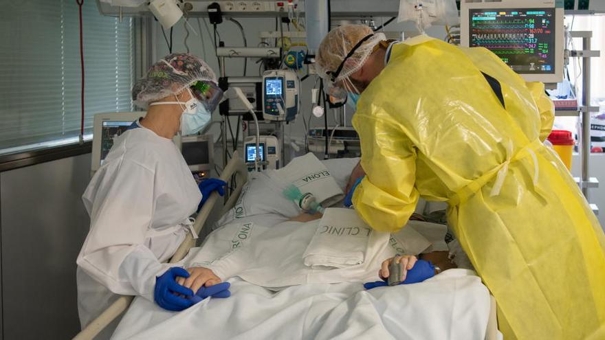 Dos sanitaris visitant un pacient de covid a l&#039;UCI de l&#039;Hospital Clínic