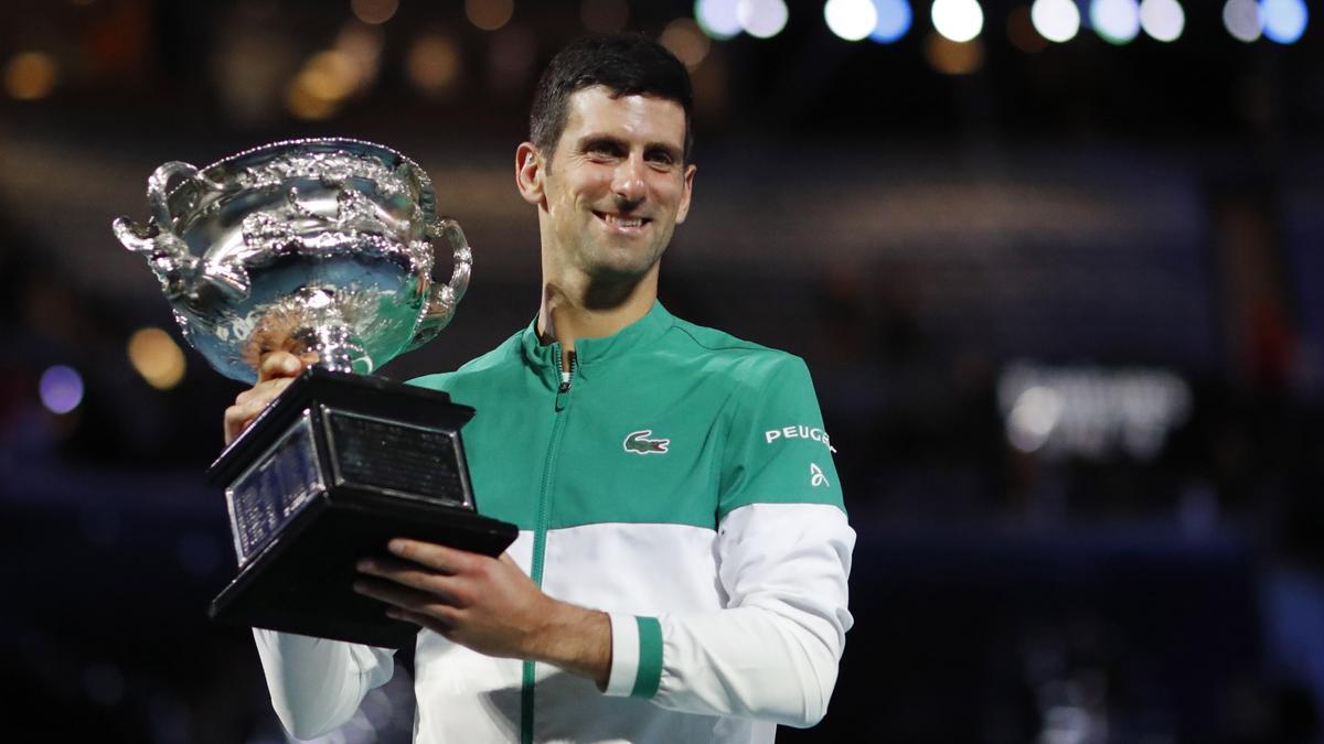 El tenista serbio Novak Djokovic posa con el trofeo como ganador del Abierto de Australia 2021