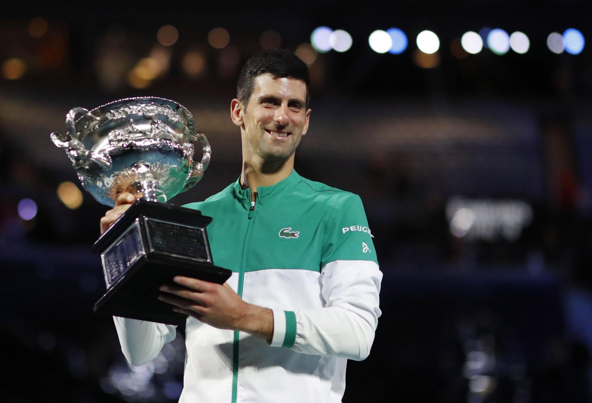 El tenista serbio Novak Djokovic posa con el trofeo como ganador del Abierto de Australia 2021