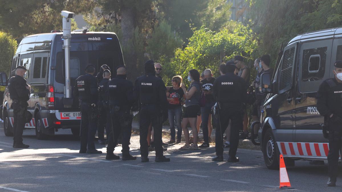 Pla general del grup de persones que ha intentat evitar el desnonament del CSOA Les Naus de Torredembarra, vigilats per agents dels Mossos d&#039;Esquadra. Foto del 14 de juliol del 2021