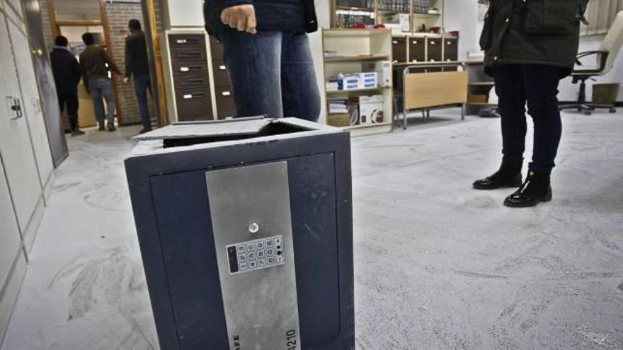 La caja fuerte en la que apenas había dinero y una de las puertas de los despachos agujereada por los ladrones para acceder.