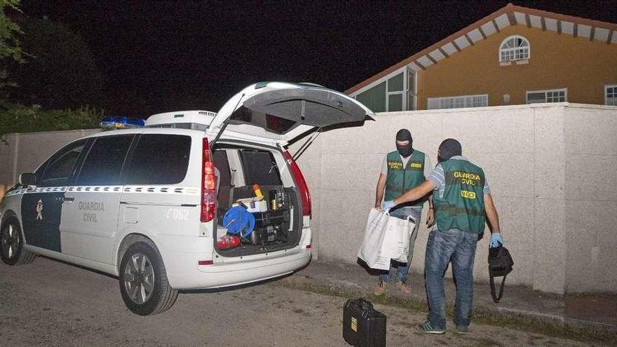 Agentes saliendo de la vivienda tras la inspección, en la medianoche del pasado miércoles. // Bernabé/Cris M.V.