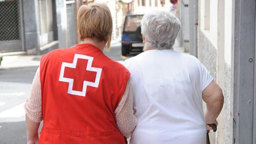 Una voluntaria de Cruz Roja ayuda a una mujer mayor.