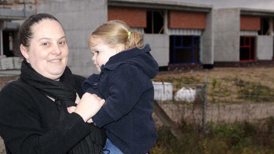 Valeria, con su pequeña, ante la obra de la guardería.  // N. Parga