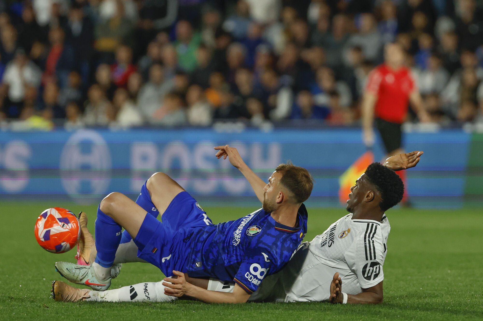 GETAFE (MADRID), 23/04/2025.- El delantero del Getafe, Borja Mayoral (i), cae ante el centrocampista francés del Real Madrid, Aurelien Tchouameni, durante el partido de la jornada 33 de LaLiga que Getafe CF y Real Madrid disputan hoy miércoles en el Coliseum de Getafe. EFE/Mariscal