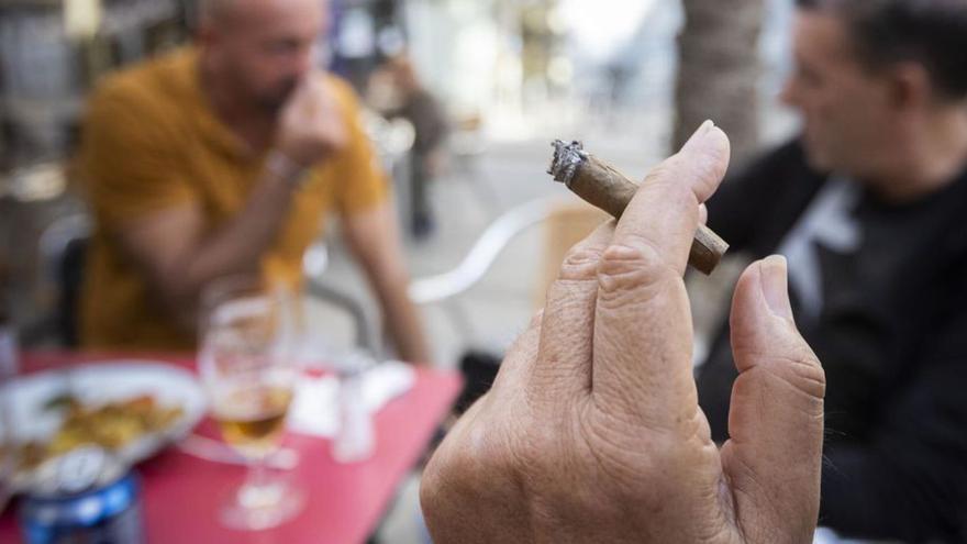 Un hombre fuma
en una terraza. | // FERRAN NADEU