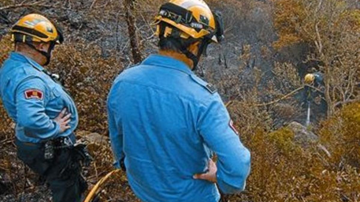 Bomberos voluntarios colaboran ayer en la extinción del fuego.