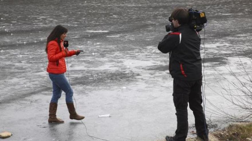 Dos reporteros de televisión sobre el hielo en el río Tera.