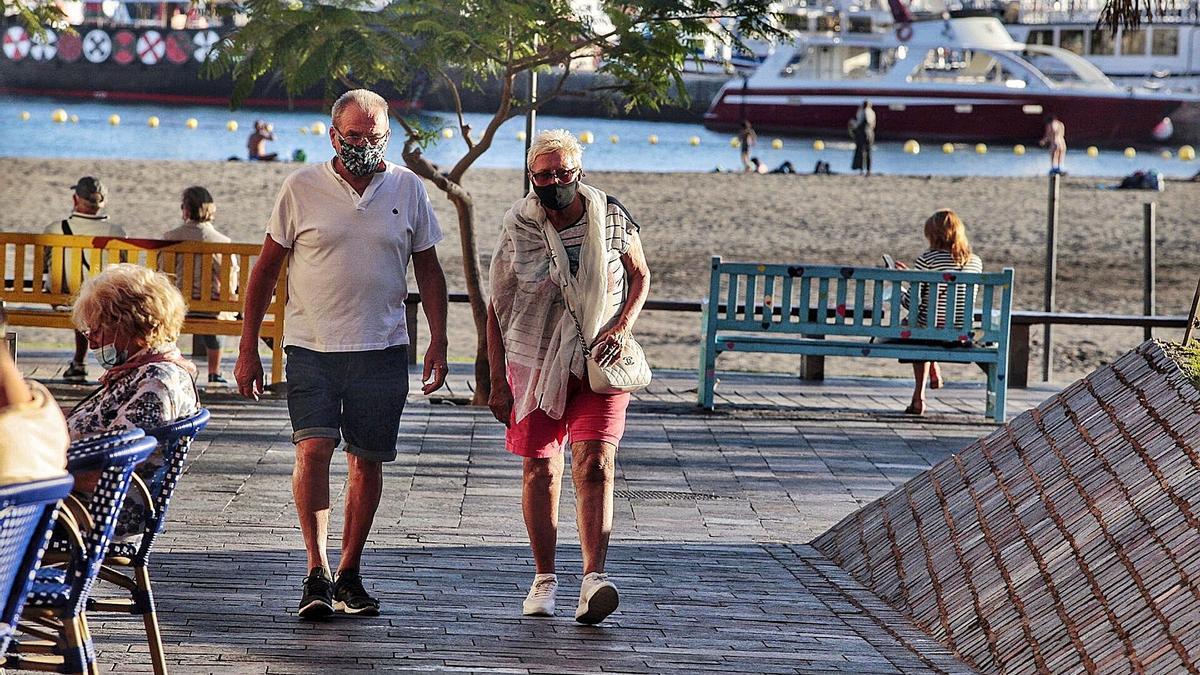 Una pareja de turistas pasea en una zona costera de Tenerife.