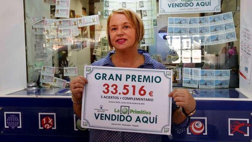 Marita Cabaleiro, ayer, muestra el cartel con el premio. // Ricardo Grobas