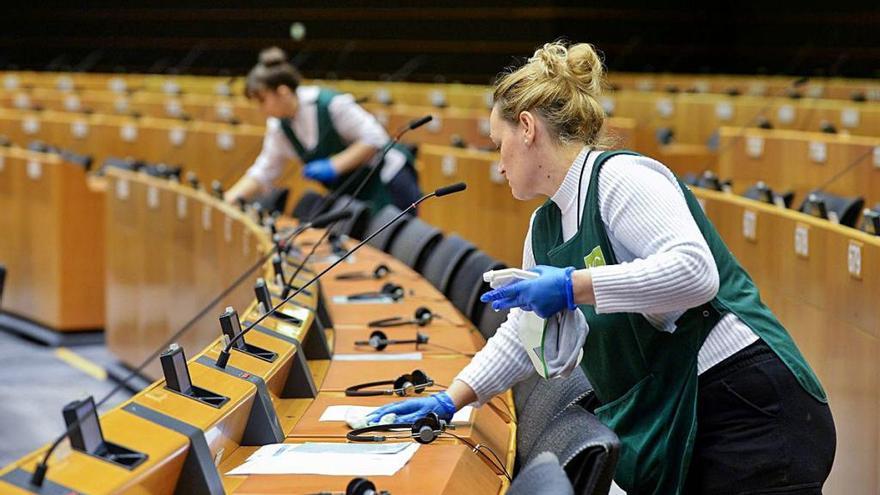 Dos trabajadoras del Parlamento Europeo desinfectan el hemiciclo antes de la última sesión presencial, el pasado martes.