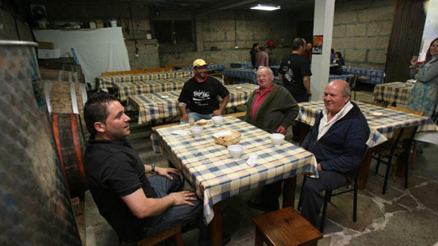 Unas personas disfrutan de unos vinos, ayer, en un furancho de Cedeira, en Redondela.  // Jesús de Arcos