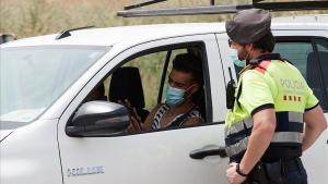 Un mosso detiene a un vehículo en el marco de los controles de movilidad habilitados en la entrada de Soses y otros municipios de Lleida por el rebrote del coronavirus.
