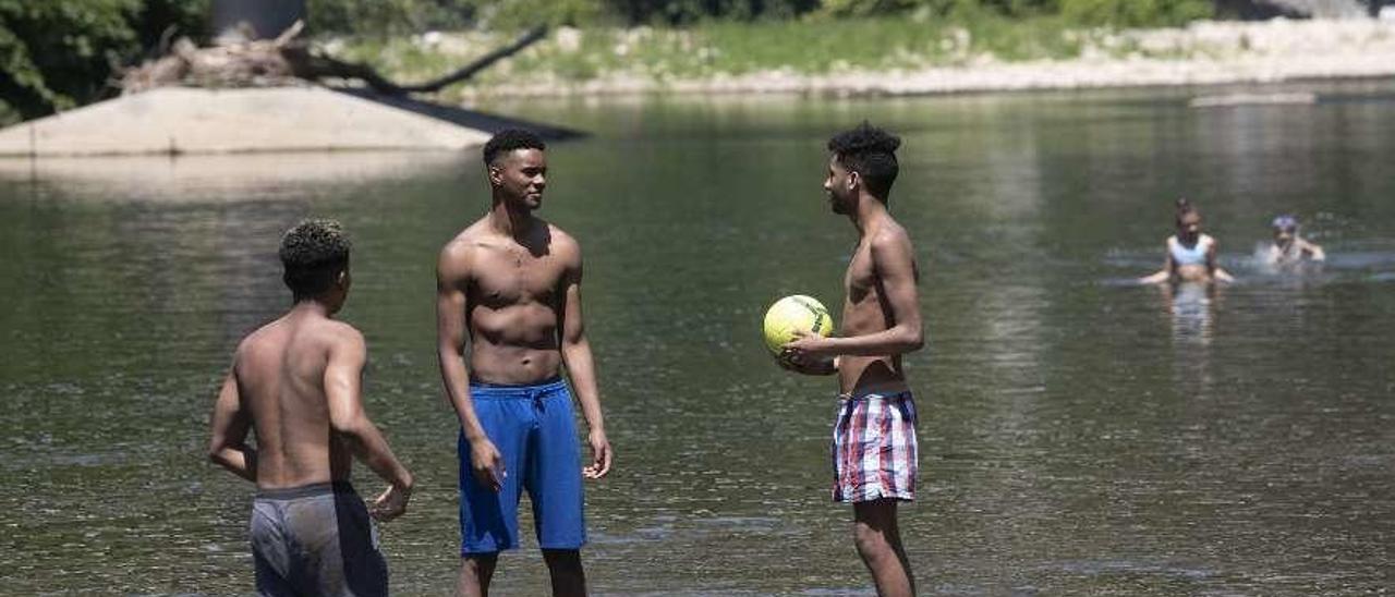 Bañistas, ayer, en el río Nalón, a escasos metros del lugar donde falleció ahogado el miércoles el joven.