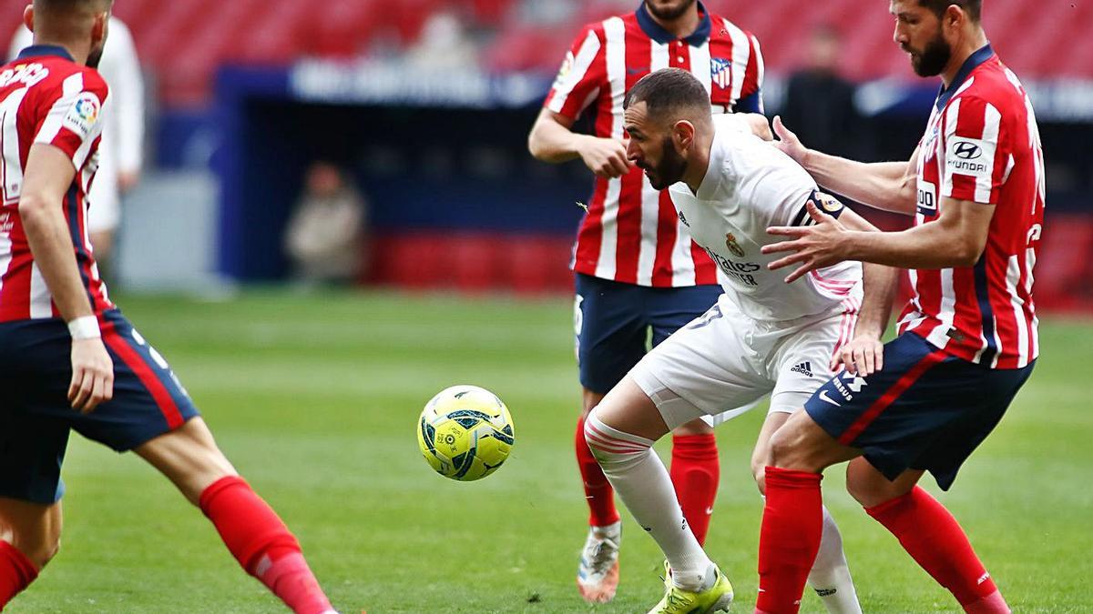 Benzema controla un balón entre los rojiblancos Koke y Felipe. |  // AGENCIAS