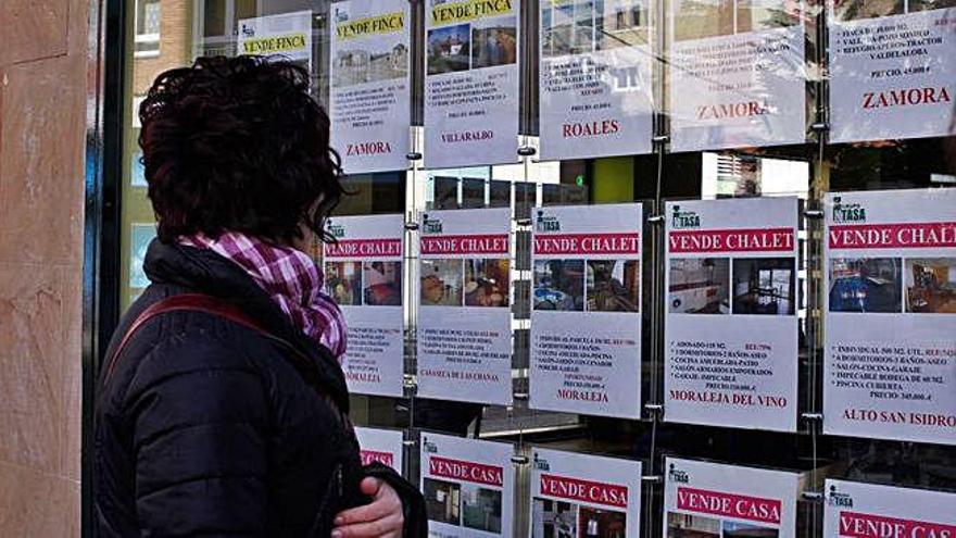 Una mujer observa las ofertas de una inmobiliaria.